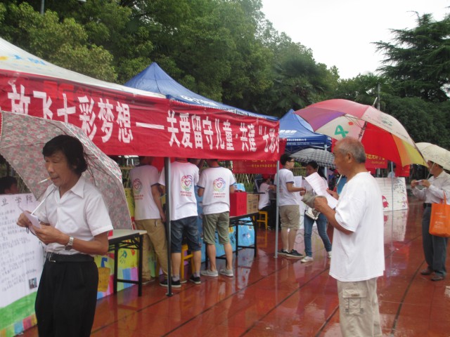 湖北汽院七彩筑梦团雨中举办爱心倡议活动