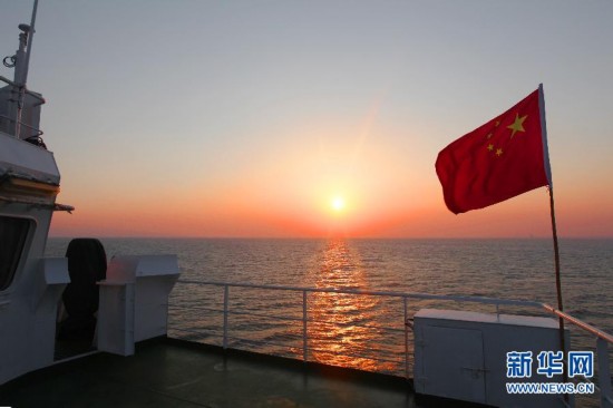 中国渔政201船上的渔政人员徐徐升起五星红旗