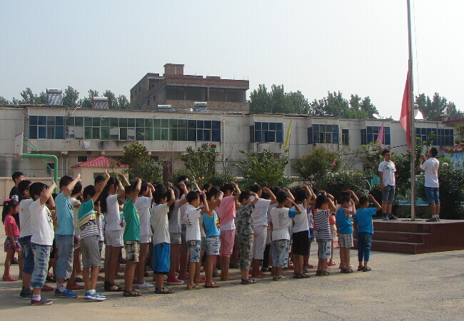 黄淮学院生物工程系2014年暑期“三下乡”志愿团在塔桥镇第一实验小学组织举行支教升旗仪式